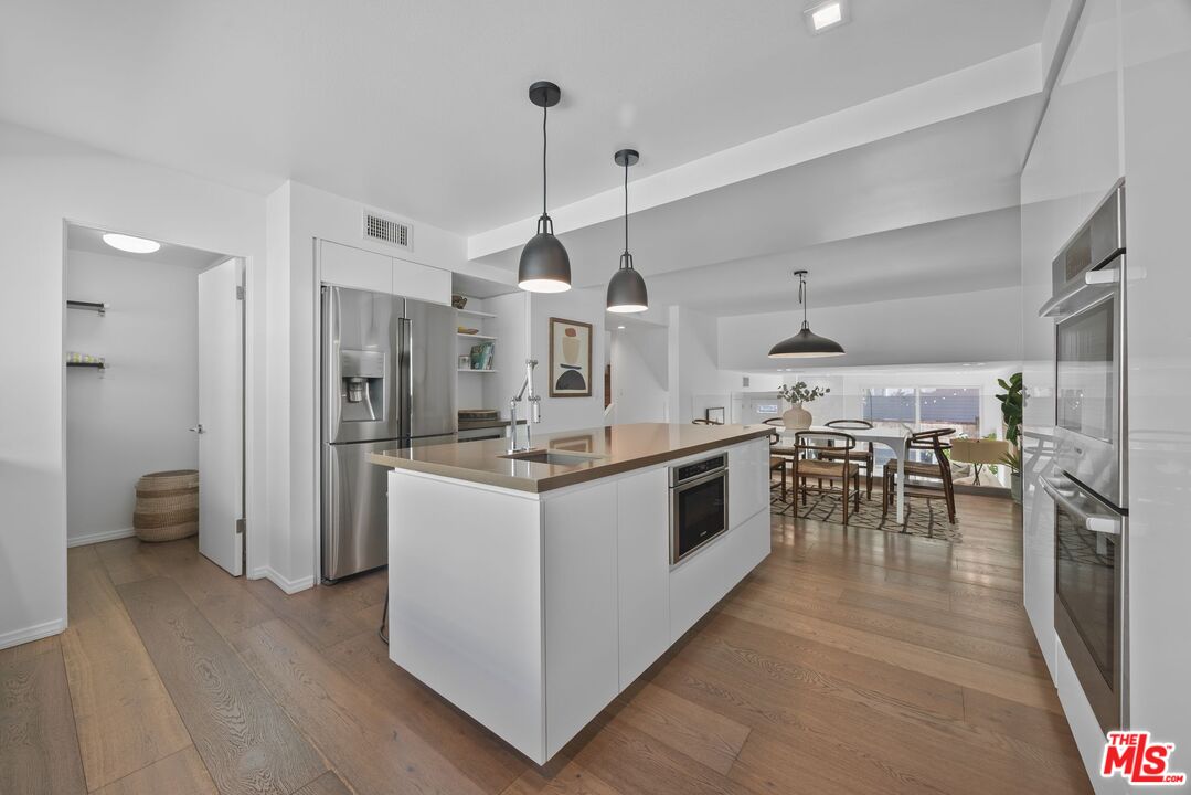 13065 Mindanao Way, Unit 3 Marina del Rey, CA 90292 - Photo 9 of 25 a kitchen with stainless steel appliances a stove top oven a sink a refrigerator and white walls