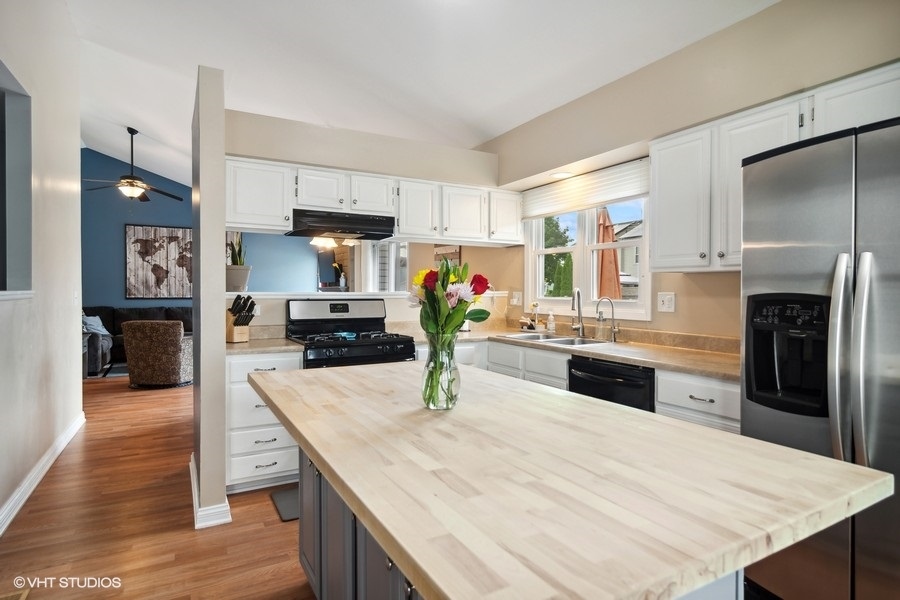 2110 Savannah Road Elgin, IL 60123 - Photo 6 of 17 a kitchen with granite countertop a refrigerator a stove and a sink