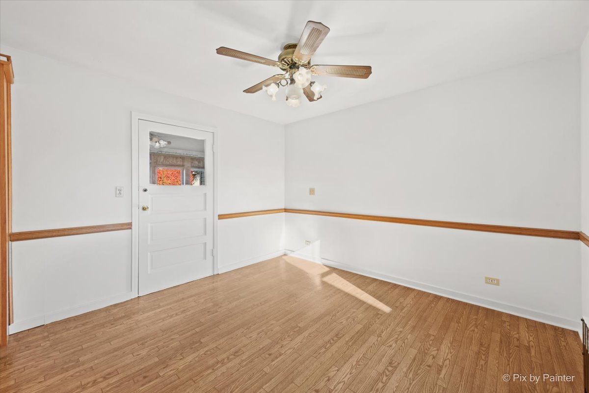 1106 West Highland Avenue Elgin, IL 60123 - Photo 18 of 47 a view of a room with wooden floor and a ceiling fan