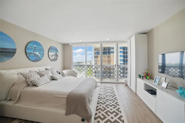 a bedroom with a balcony a bed and a flat screen tv