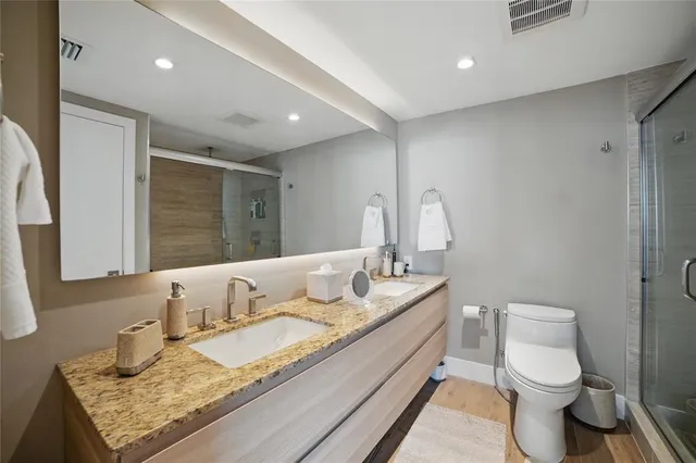 a en suite bathroom with a granite countertop sink and a mirror