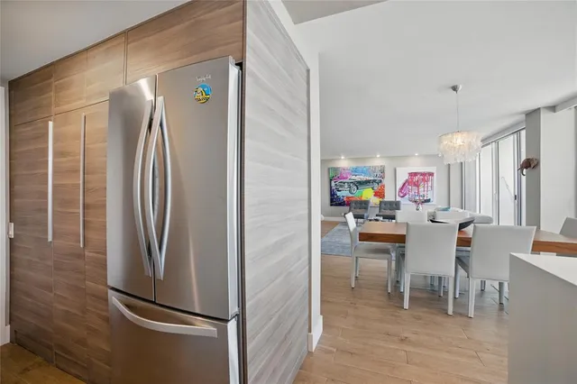 a dining room with stainless steel appliances a refrigerator and a dining table