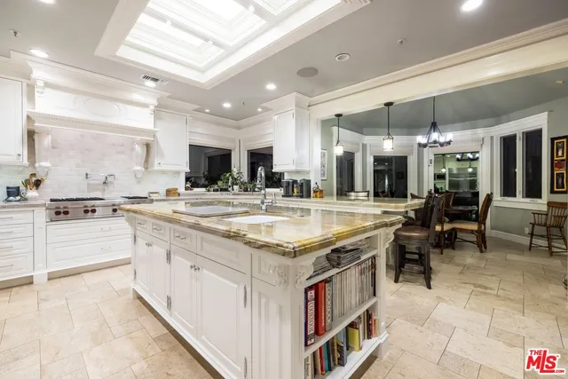 a large kitchen with a large counter top kitchen island stainless steel appliances and cabinets