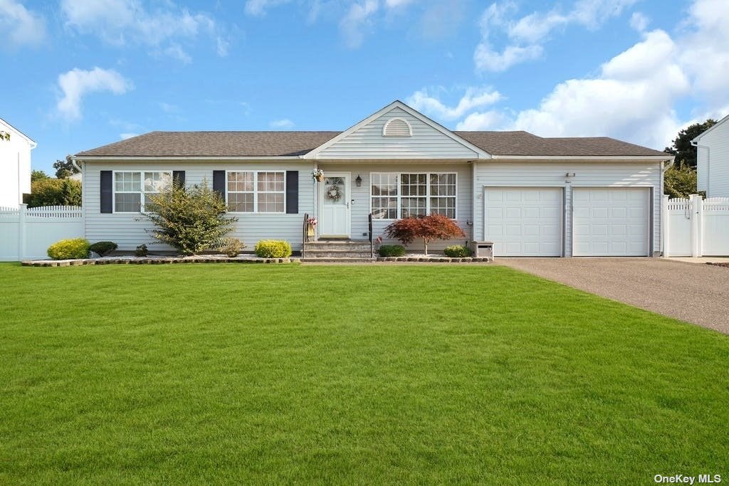 4 Sun Valley Lane Bellport, NY 11713 - Photo 1 of 1 a front view of a house with a yard and garage