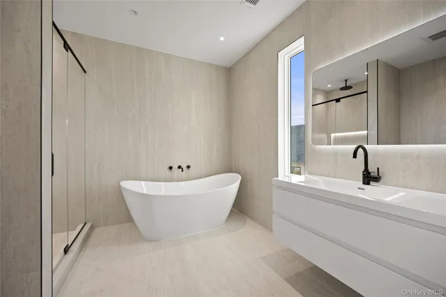 a bathroom with a bathtub sink and mirror