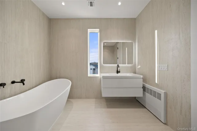 a white bath tub sitting under a bathroom
