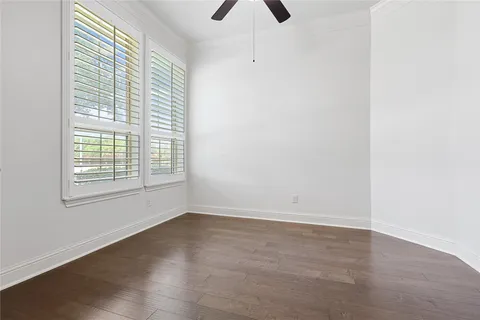 an empty room with a window and a ceiling fan