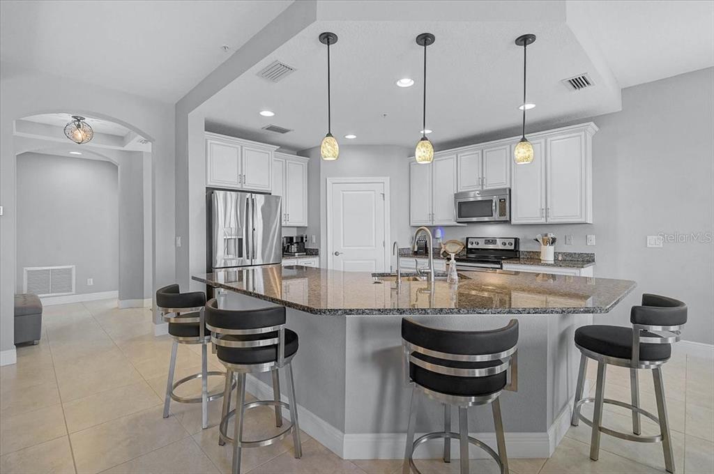 1258 Riverscape Street, Unit A Bradenton, FL 34208 - Photo 8 of 63 a kitchen with stainless steel appliances a dining table chairs stove and white cabinets