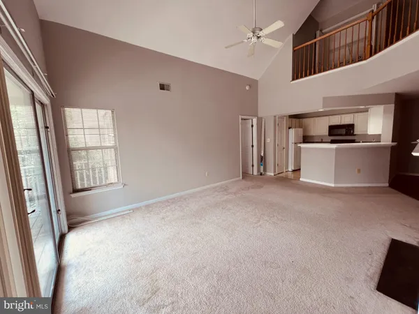 a view of kitchen with stainless steel appliances wooden floor and window
