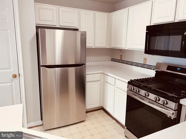 a white refrigerator freezer and a stove sitting inside of a kitchen