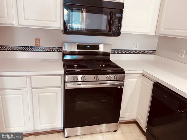 a stove top oven sitting inside of a kitchen