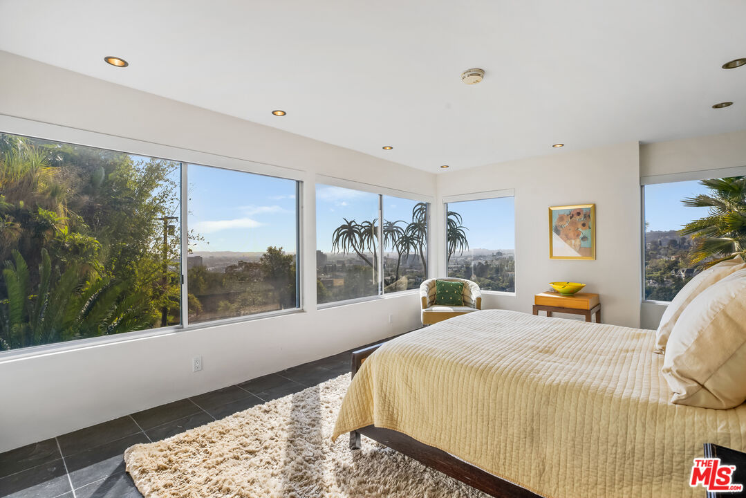 5693 Holly Oak Drive Los Angeles, CA 90068 - Photo 15 of 26 a bedroom with a large bed and a large window