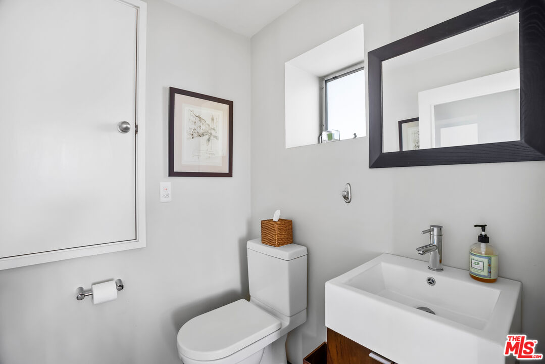 5693 Holly Oak Drive Los Angeles, CA 90068 - Photo 18 of 26 a white toilet sitting next to a bathroom sink