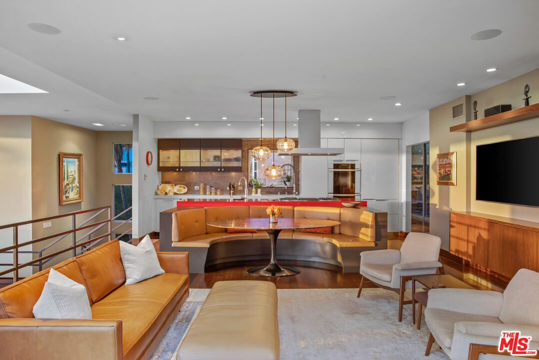 5693 Holly Oak Drive Los Angeles, CA 90068 - Photo 4 of 26 a living room with furniture a flat screen tv and kitchen view