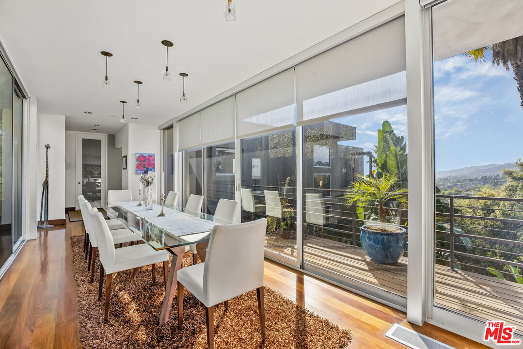5693 Holly Oak Drive Los Angeles, CA 90068 - Photo 8 of 26 a view of a dining room with furniture wooden floor and a floor to ceiling window