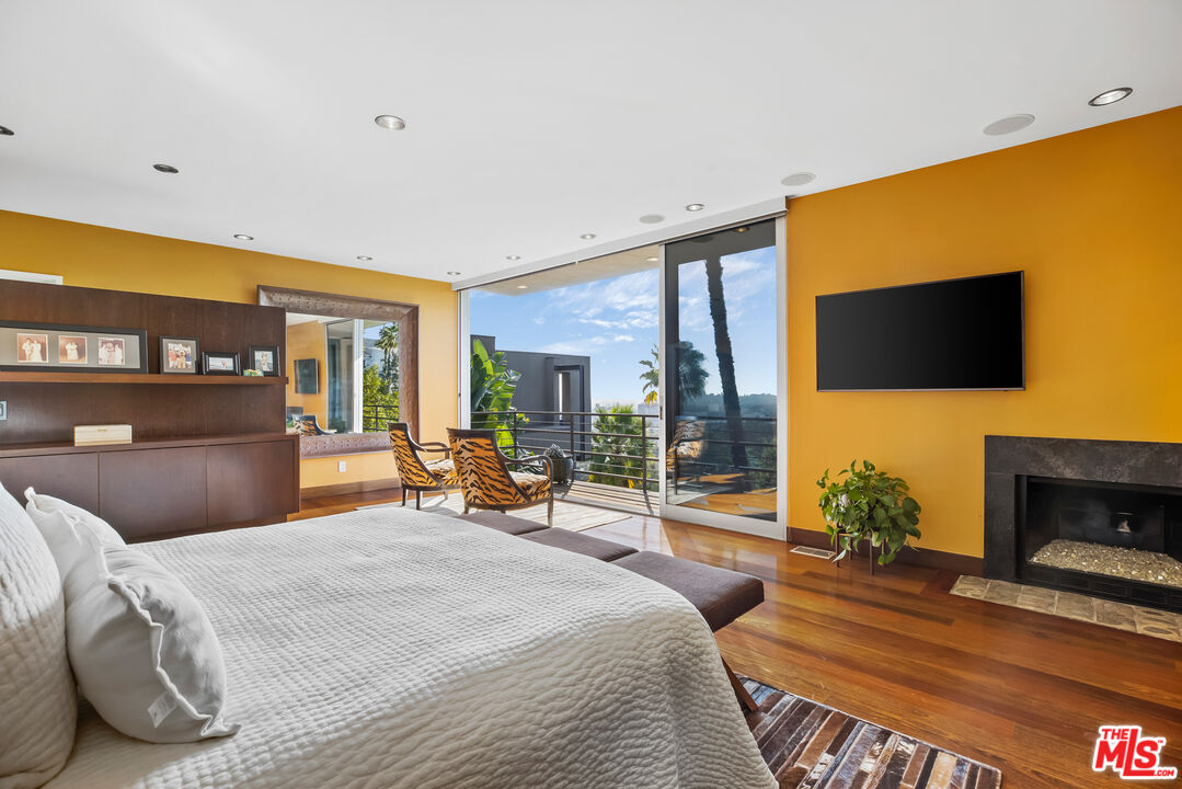 5693 Holly Oak Drive Los Angeles, CA 90068 - Photo 10 of 26 a bedroom with a bed and a flat screen tv