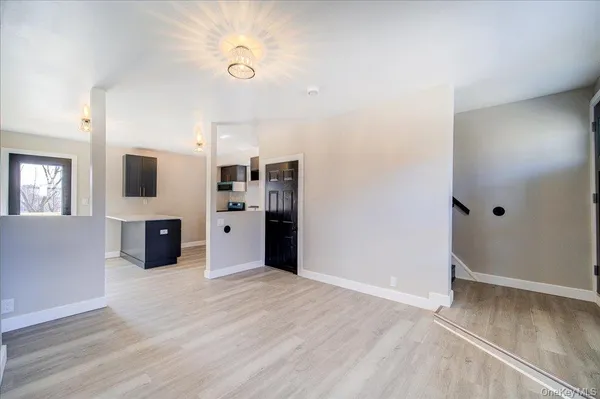 a large kitchen with stainless steel appliances a large counter top a stove and a wooden floors