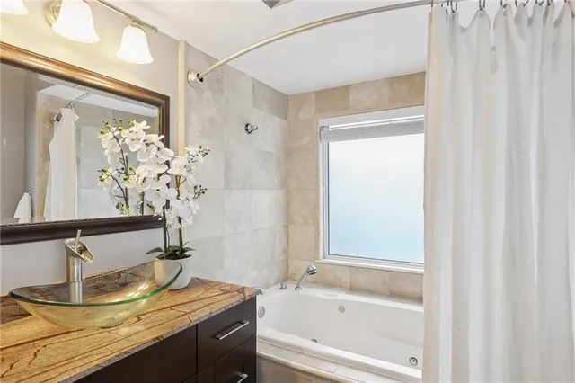 a bathroom with a granite countertop sink and a mirror