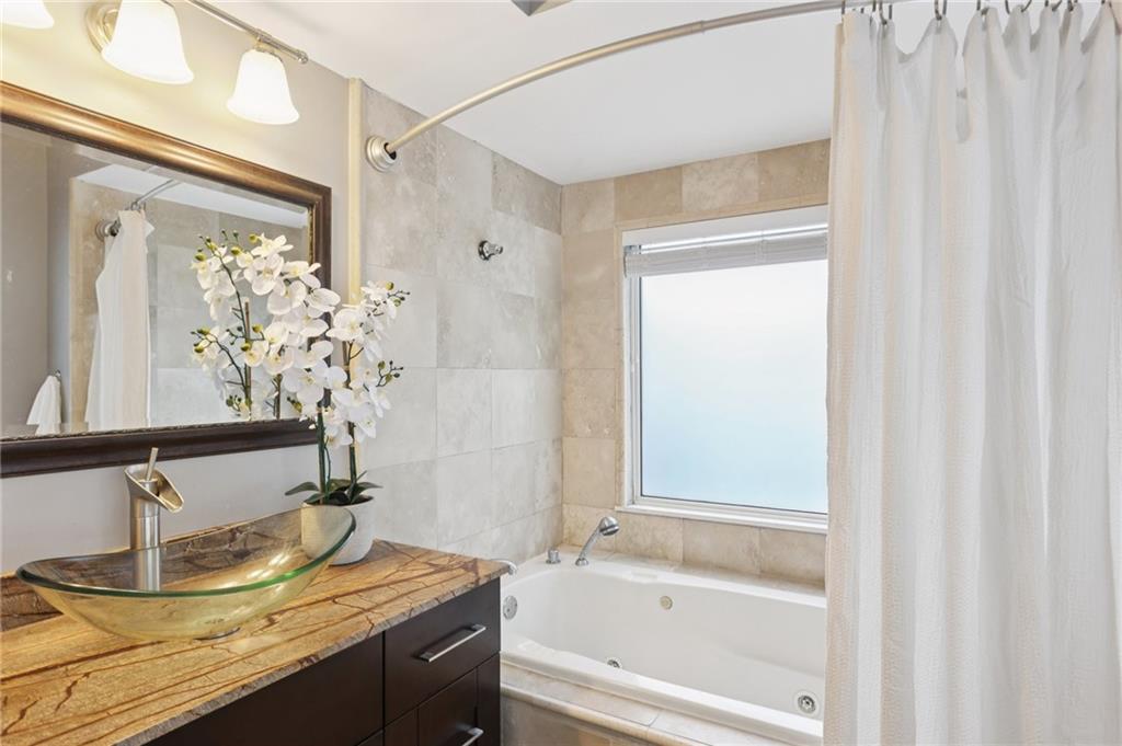 275 13th Street Northeast, Unit 312 Atlanta, GA 30309 - Photo 13 of 31 a bathroom with a granite countertop sink and a mirror