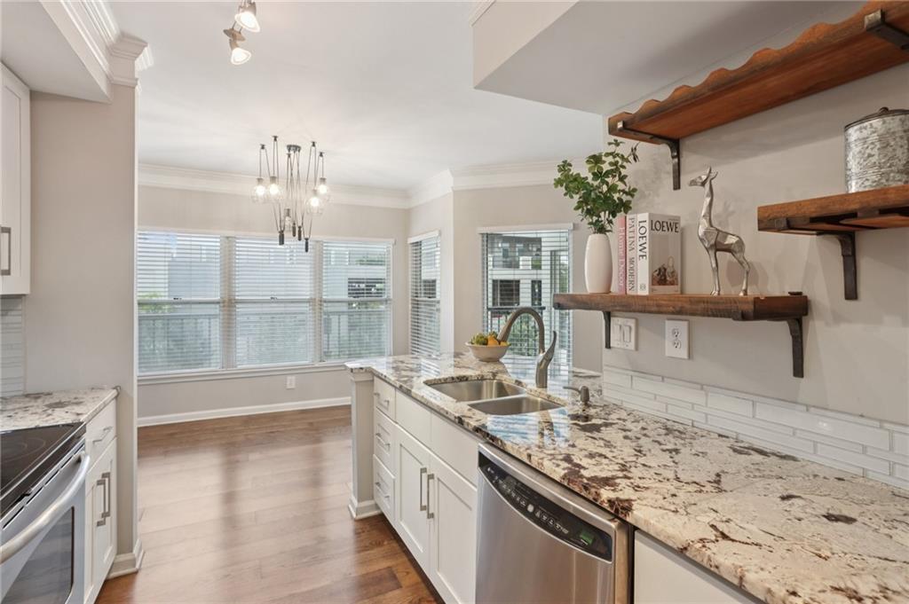 275 13th Street Northeast, Unit 312 Atlanta, GA 30309 - Photo 2 of 31 a kitchen with stainless steel appliances granite countertop a sink stove and refrigerator