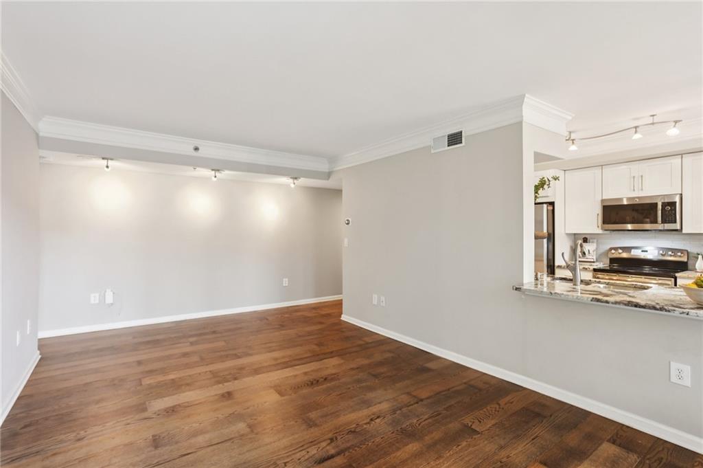 275 13th Street Northeast, Unit 312 Atlanta, GA 30309 - Photo 7 of 31 a view of a kitchen with wooden floor and a sink