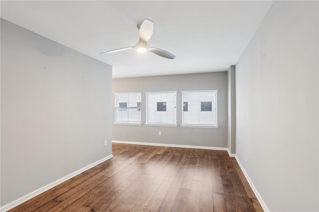 275 13th Street Northeast, Unit 312 Atlanta, GA 30309 - Photo 10 of 31 an empty room with wooden floor and windows