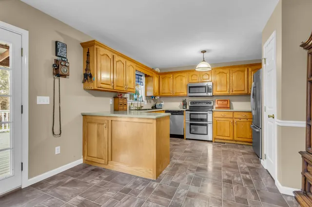 a kitchen with stainless steel appliances granite countertop a stove a sink and a refrigerator