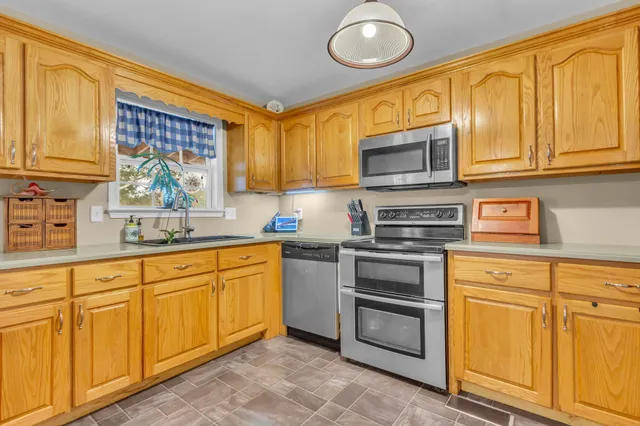 a kitchen with stainless steel appliances granite countertop a stove and cabinets