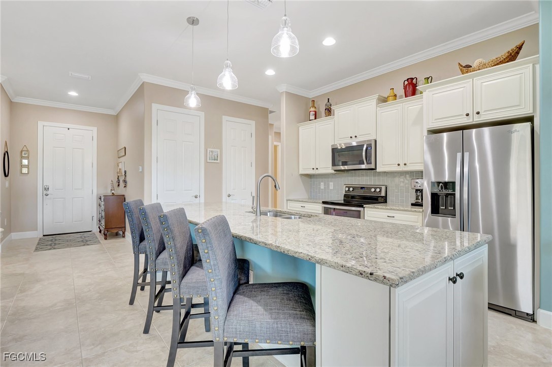 11716 Avingston Terrace Fort Myers, FL 33913 - Photo 10 of 49 a kitchen with stainless steel appliances granite countertop a sink a stove a refrigerator cabinets and a dining table