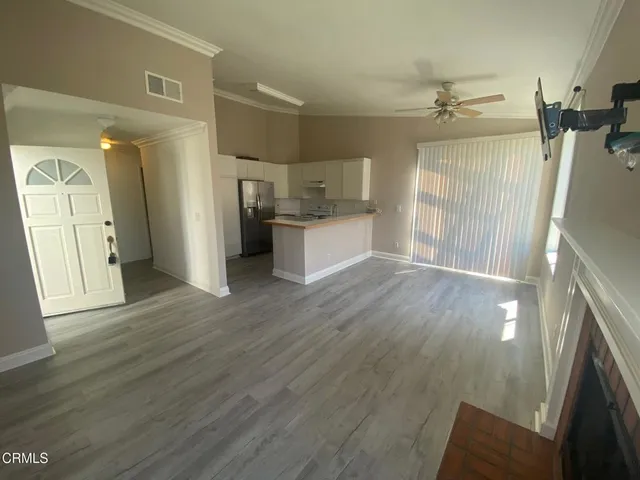 a open kitchen with white cabinets and wooden floor