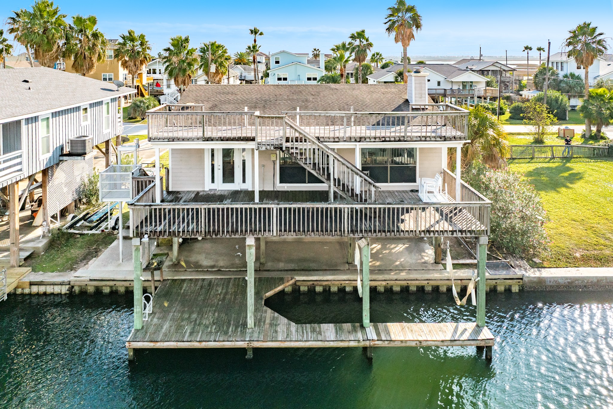 View of home from canal. Property has a vinyl bulkhead, the concrete cap nees replacing.
