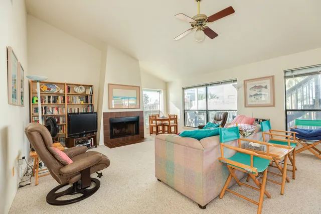 a living room with furniture a fireplace and a flat screen tv