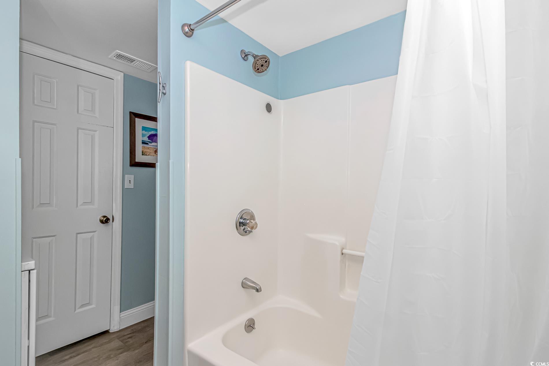 301 North Waccamaw Drive, Unit 211 Murrells Inlet, SC 29576 - Photo 9 of 37 Full bath featuring shower / tub combo and wood finished floors
