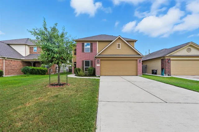 a front view of a house with a yard and garage