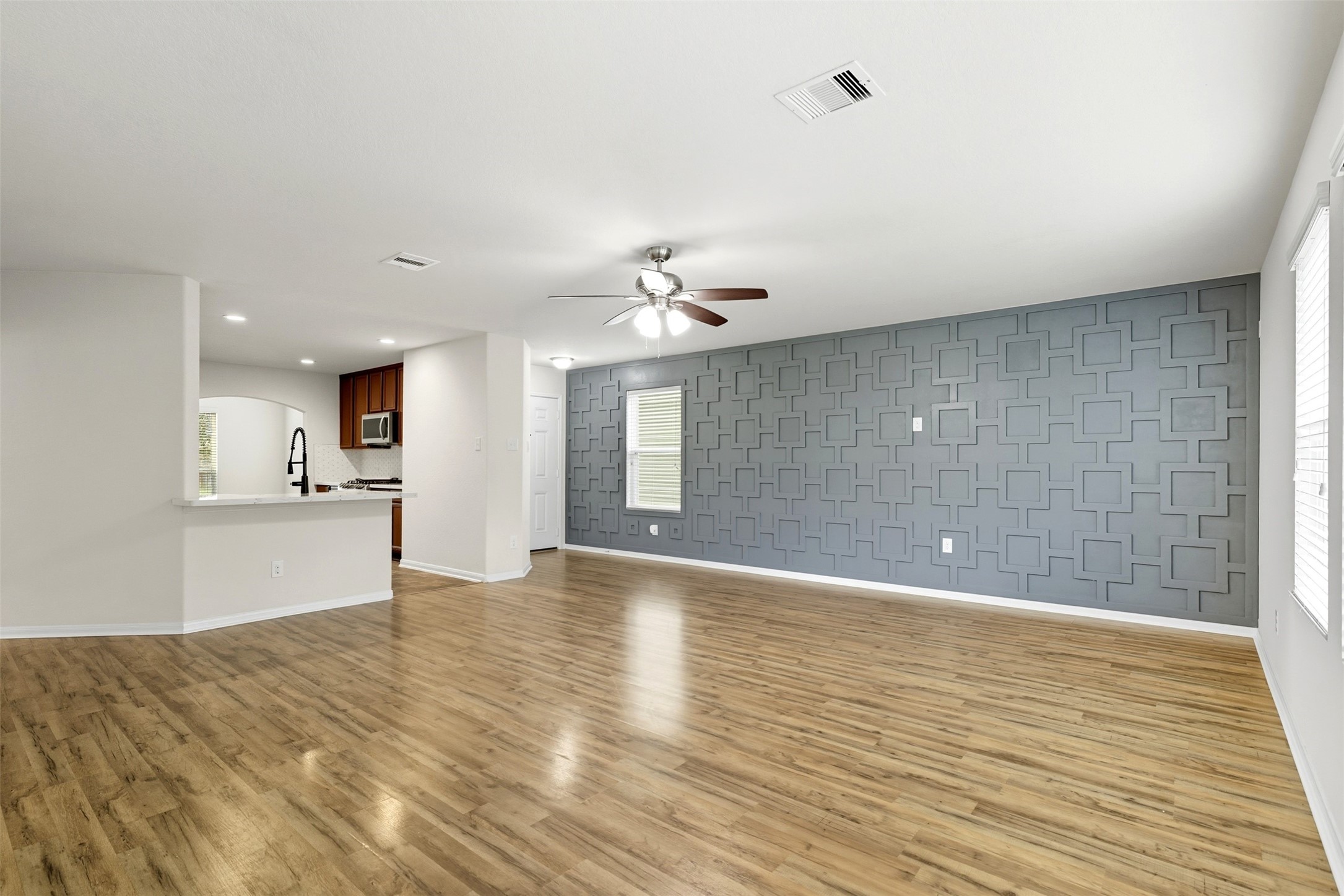 18414 West Hardy Road Houston, TX 77073 - Photo 5 of 46 a view of an empty room with wooden floor and a kitchen