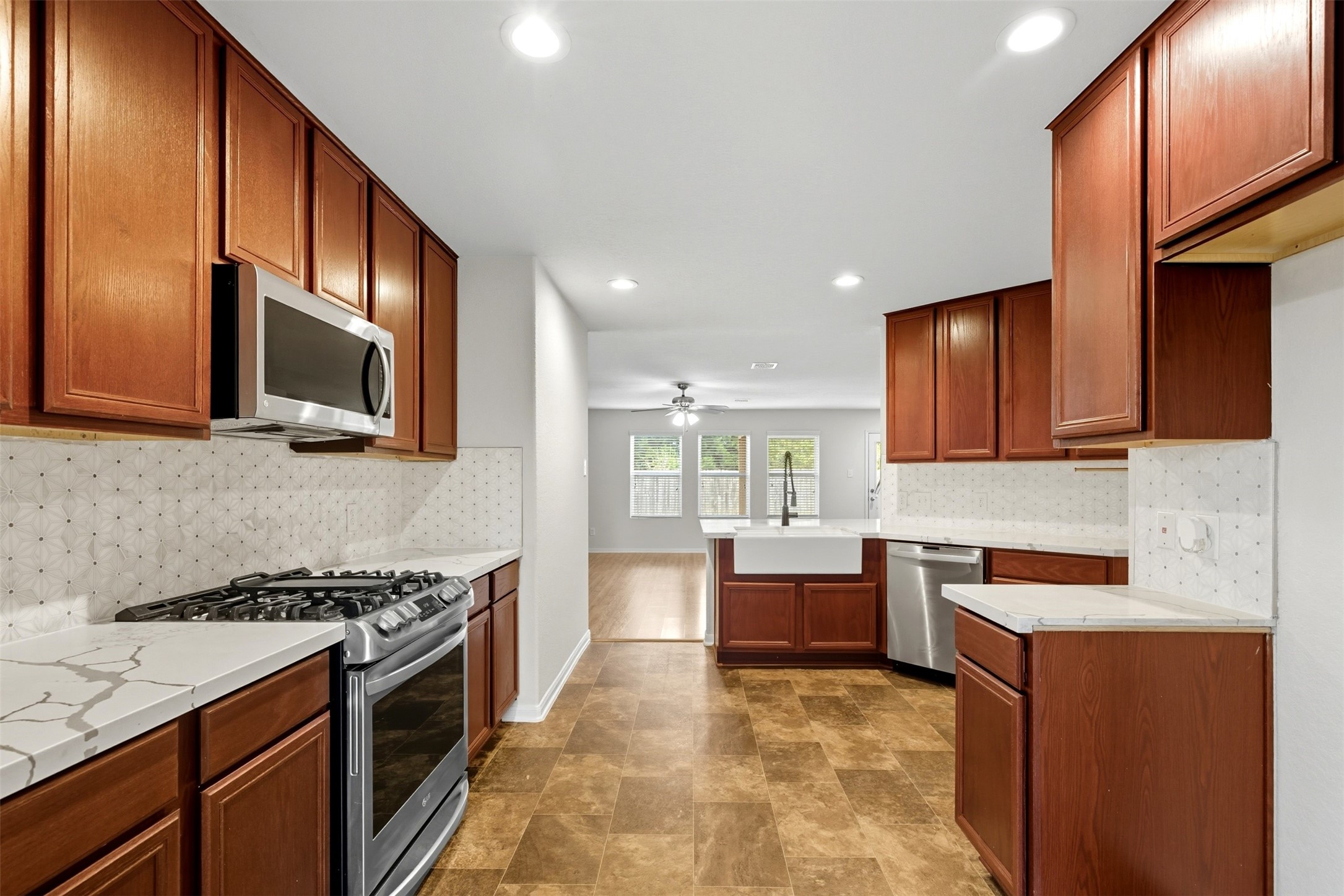 18414 West Hardy Road Houston, TX 77073 - Photo 7 of 46 a kitchen with stainless steel appliances granite countertop a stove top oven a sink dishwasher and wooden cabinets with wooden floor