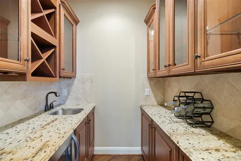 a kitchen with granite countertop a sink a stove and cabinets