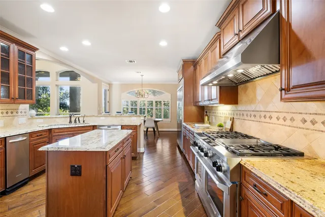 a kitchen with stainless steel appliances granite countertop a stove and a sink