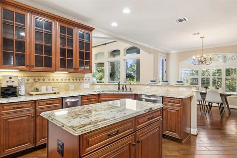 a kitchen with a stove and a wooden floor