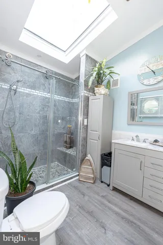 a bathroom with a granite countertop sink a toilet and shower
