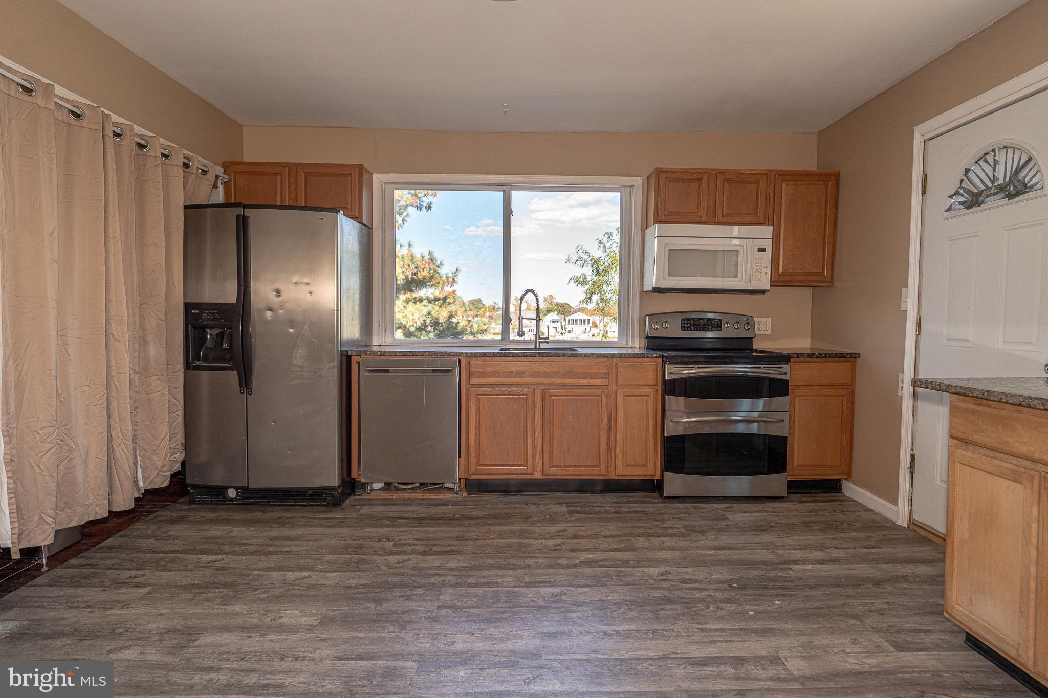 8514 Sandy Plains Road Dundalk, MD 21222 - Photo 22 of 34 a kitchen with stainless steel appliances a refrigerator and a stove top oven