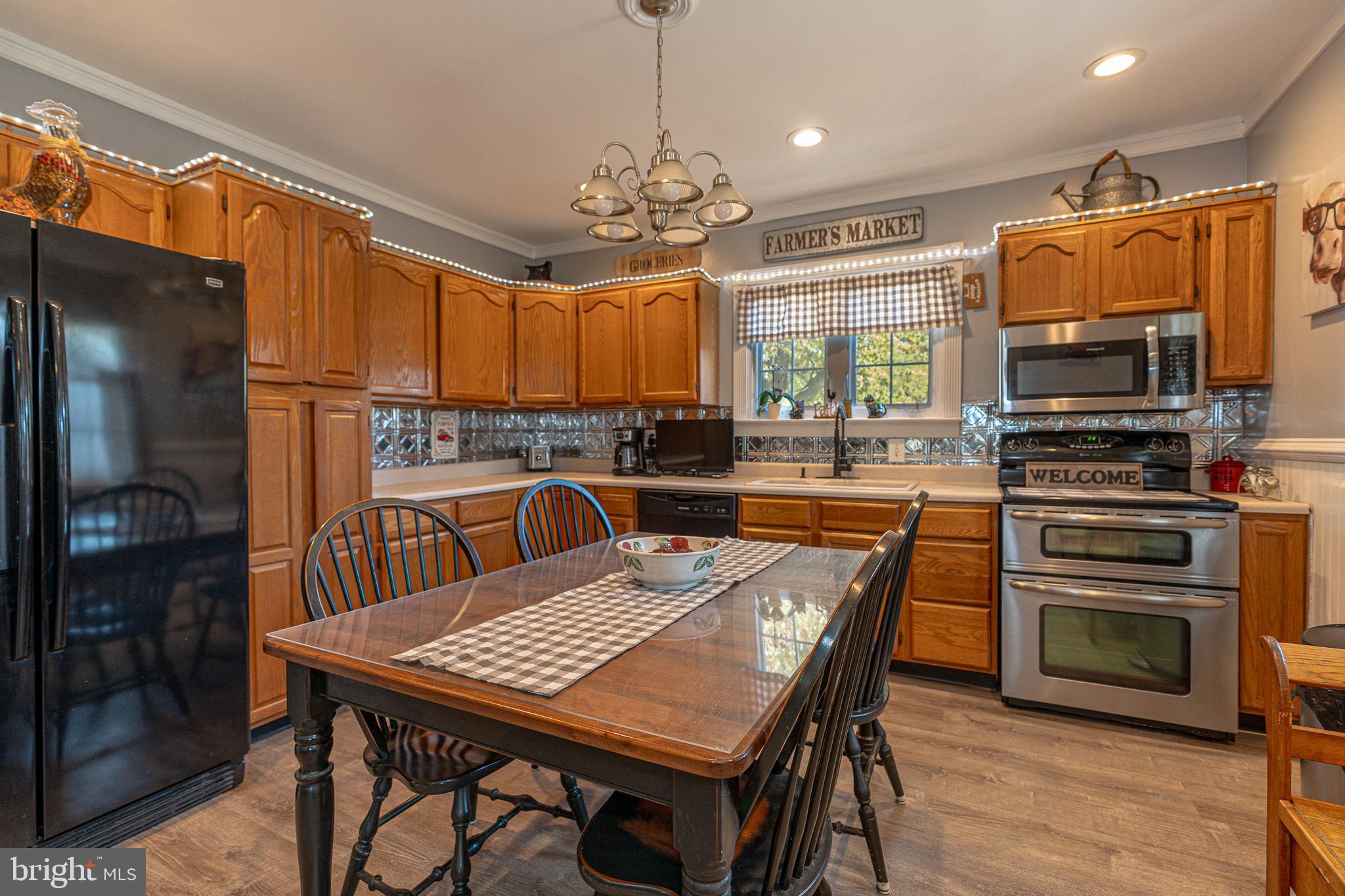 8514 Sandy Plains Road Dundalk, MD 21222 - Photo 9 of 34 a kitchen with a table chairs microwave and refrigerator