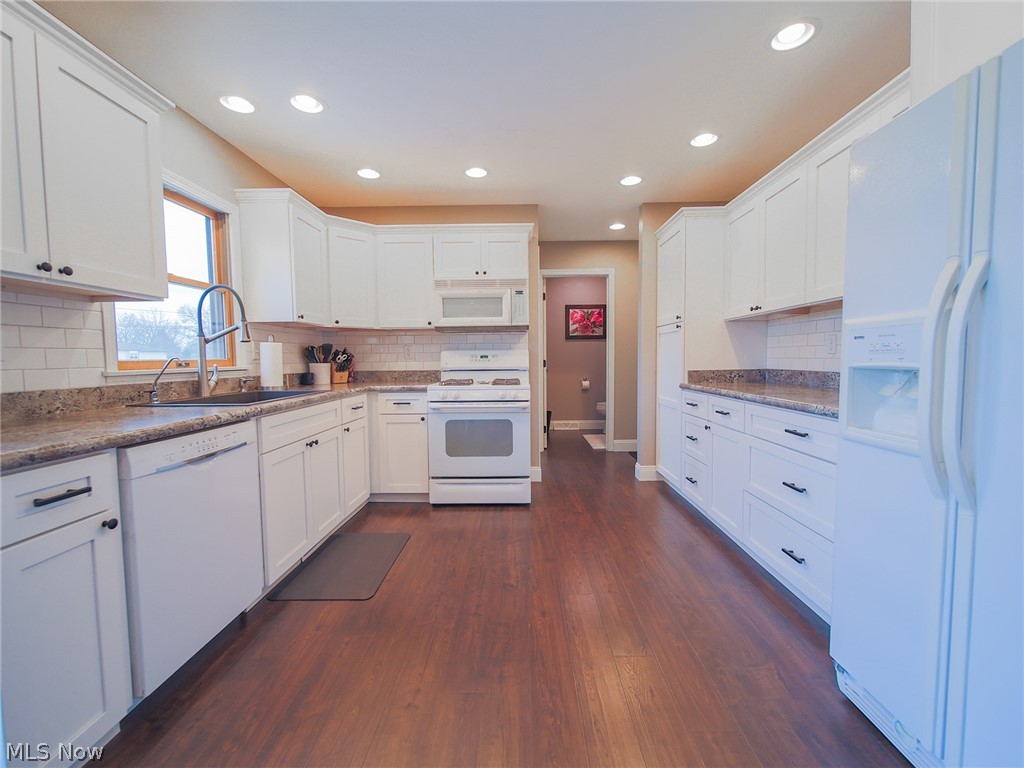 4993 Emalene Road Wooster, OH 44691 - Photo 10 of 30 Kitchen featuring white appliances, backsplash, and dark hardwood / wood-style floors