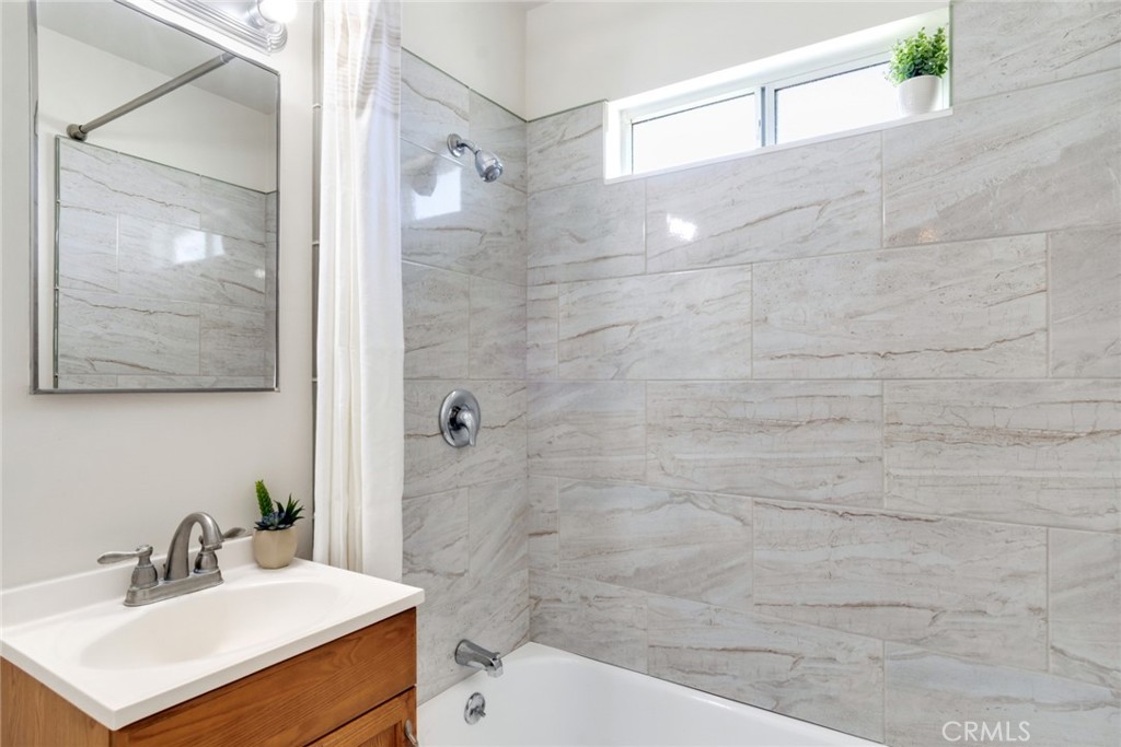 8955 Holly Lane Riverside, CA 92503 - Photo 10 of 32 a bathroom with a sink mirror and a shower