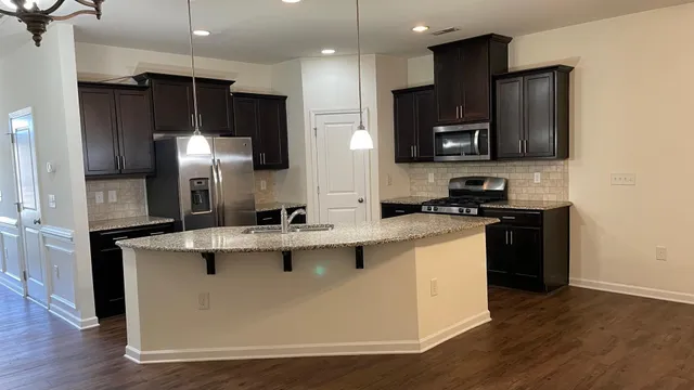 a kitchen with kitchen island a sink stainless steel appliances and cabinets
