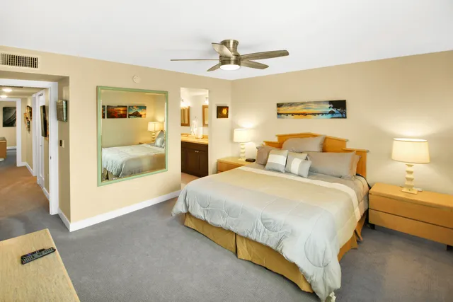 a spacious bedroom with a bed and a dresser