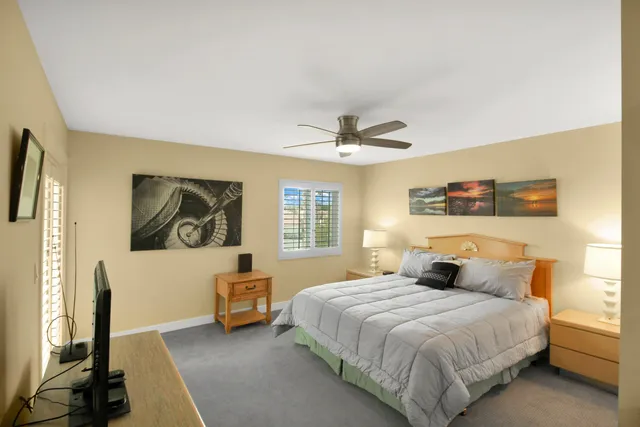 a bedroom with a bed and a flat tv screen on dresser