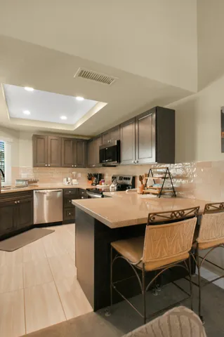a kitchen with a sink and chairs