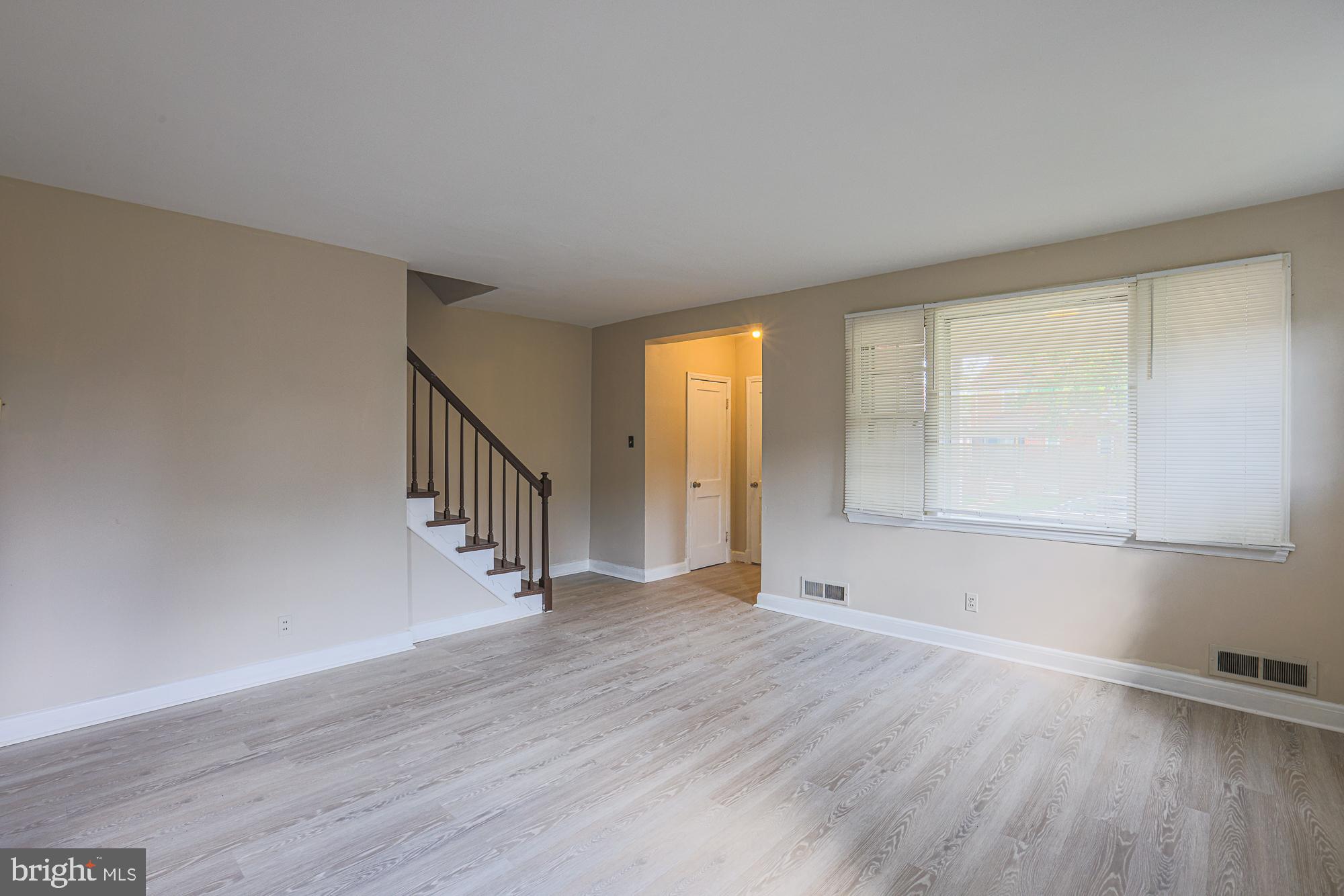 3914 Bancroft Road Baltimore, MD 21215 - Photo 6 of 25 a view of an empty room with wooden floor and a window