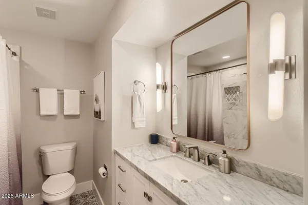 a bathroom with a granite countertop sink toilet and shower